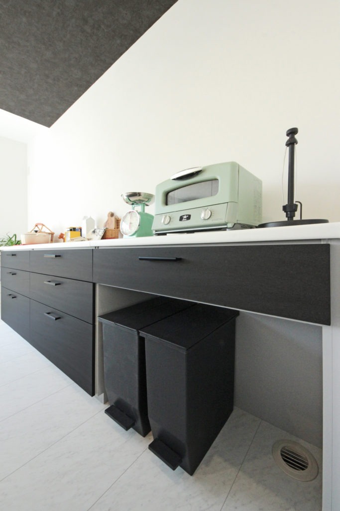 愛知県蒲郡市の注文住宅のキッチン。イリートデザイン一級建築士事務所による、黒い面材と白い天板がおしゃれな造作風の背面収納。